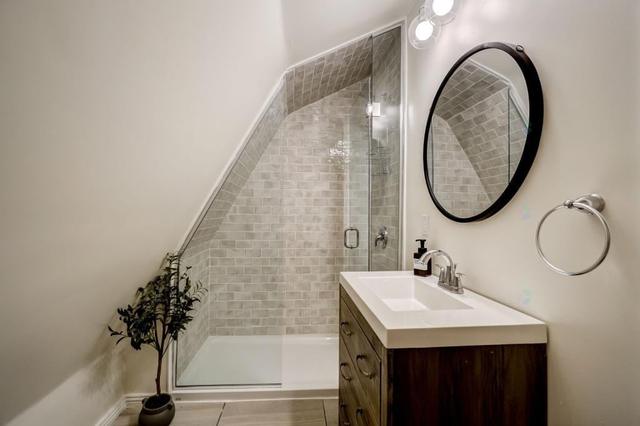 Bathroom with round mirror and glass shower