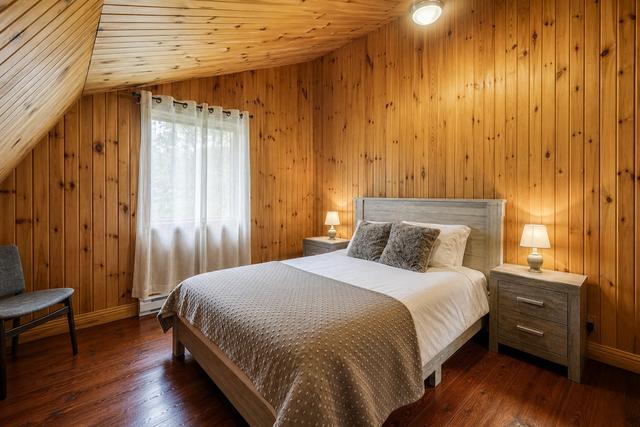 A queen bedroom with a crib beside the bed