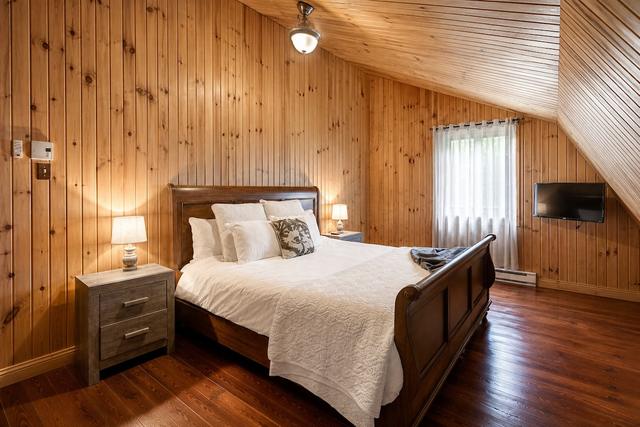 A queen bedroom with tall windows onto the trees