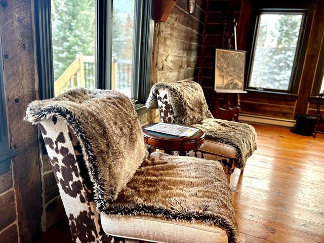 Cowhide armchairs beside a tall window in the great room