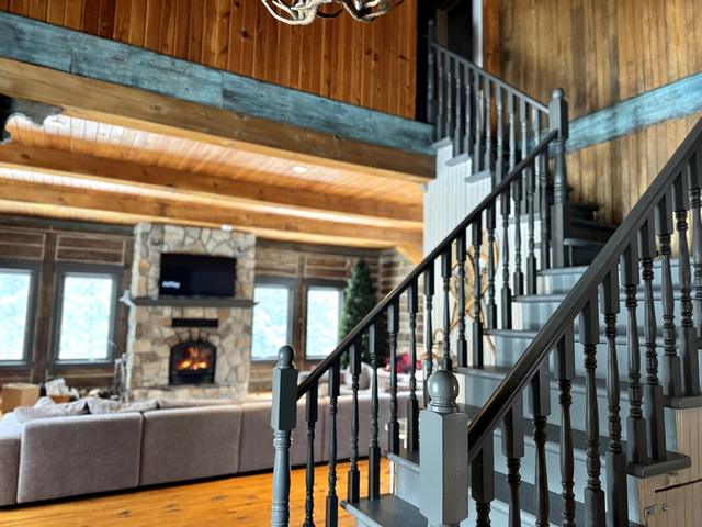 The great room seen from the staircase, fireplace lit
