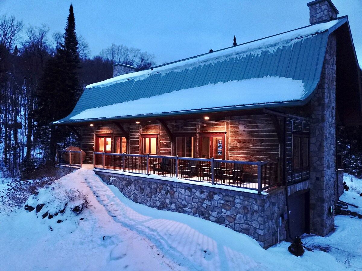 Station Tremblant at winter twilight, a log-and-stone former railway station under snow