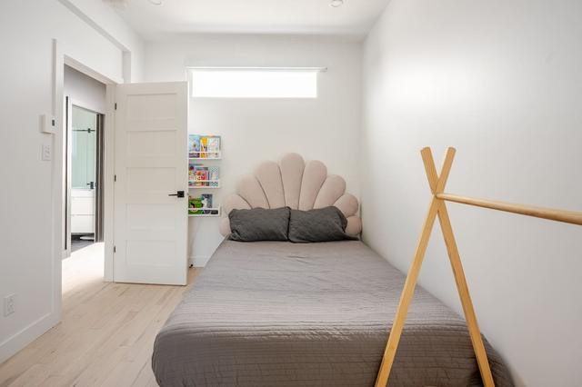 A queen bedroom with a play teepee and bookshelf