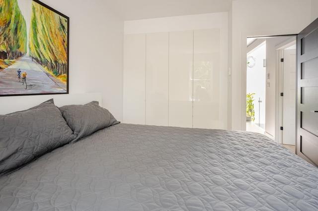 Queen bed under a landscape painting