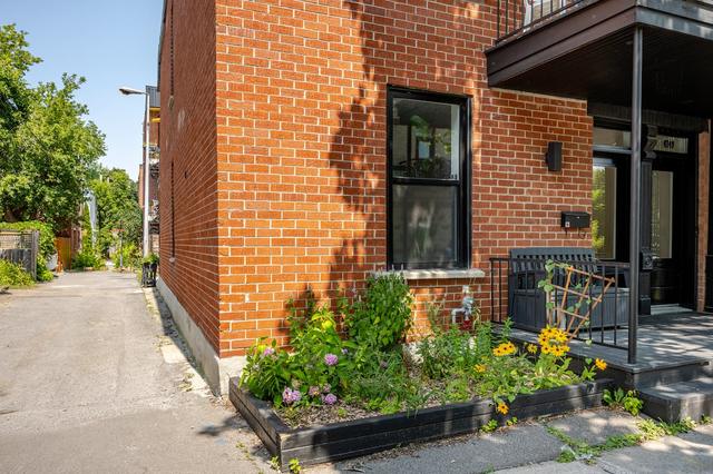 The brick corner of the house with a flower bed