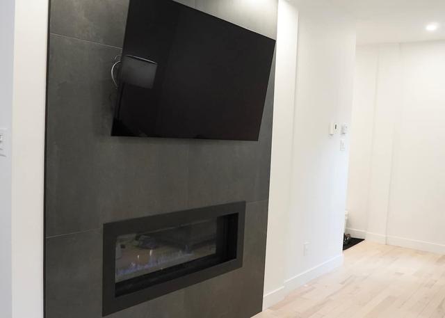 Gas fireplace set into slate with a television above