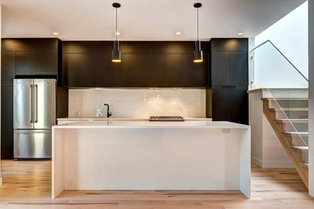 Kitchen island with black cabinets and the staircase beyond