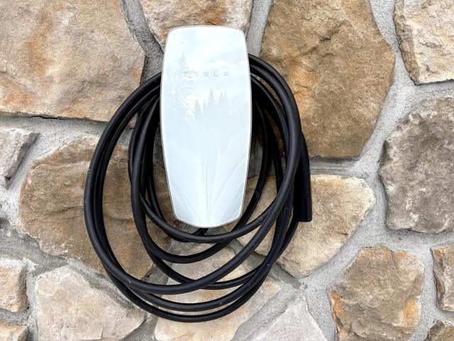 Tesla wall charger on the stone foundation