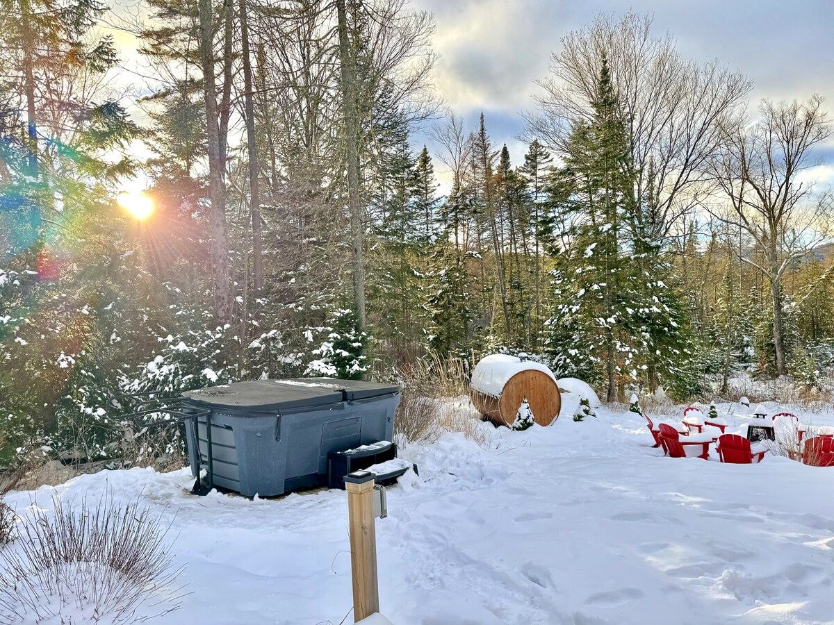 Low winter sun over the barrel sauna and hot tub in deep snow